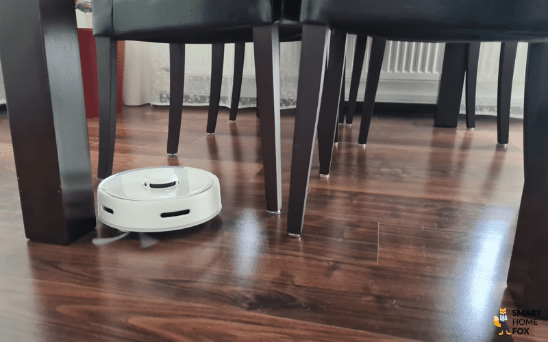 Der SwitchBot K10+ reinigt zwischen den Stühlen.